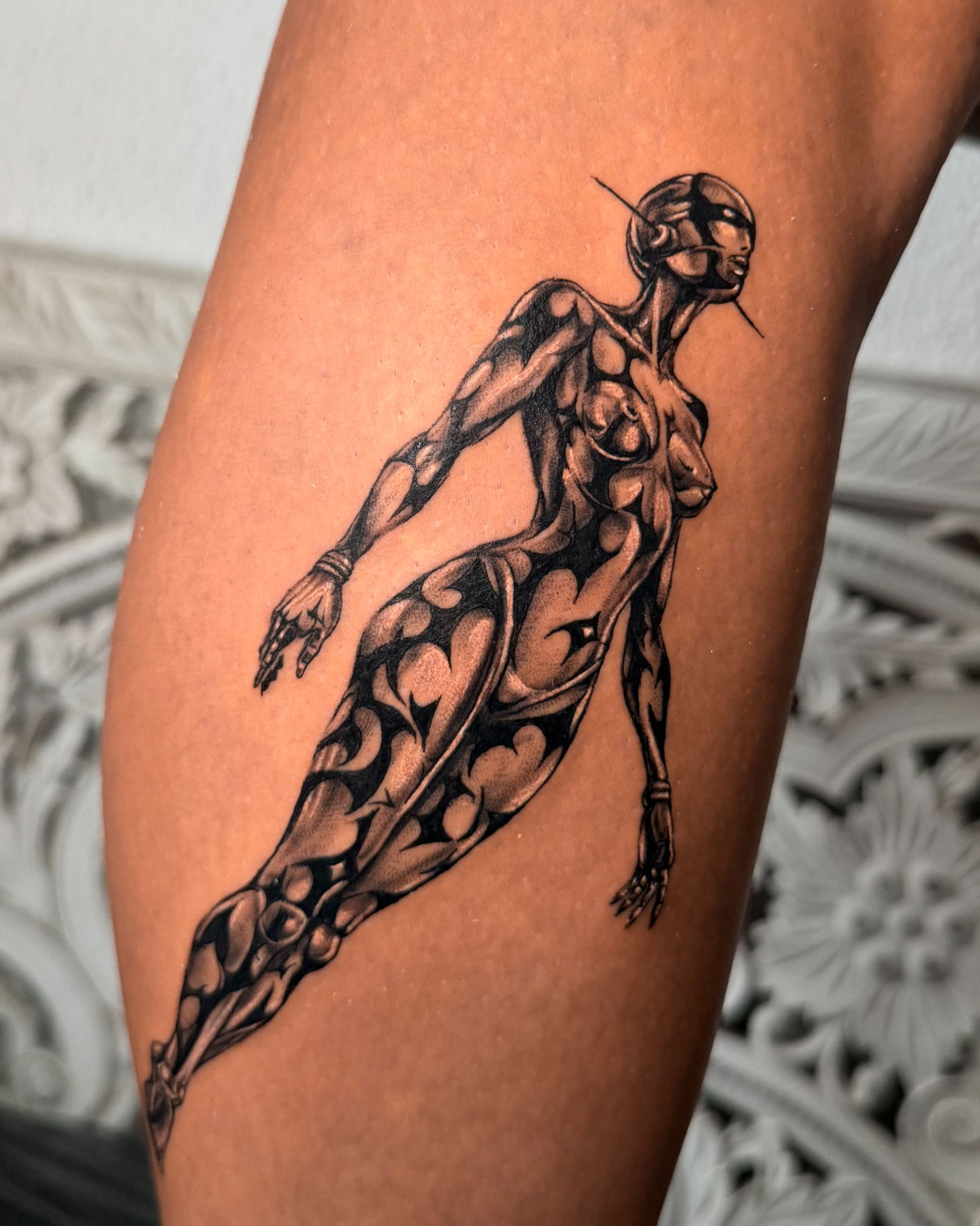 Chrome female figure tattoo by Wilson